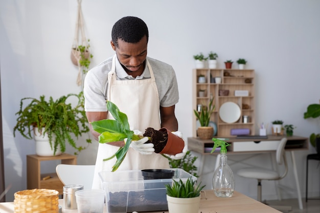 Medium shot man transplanting plant