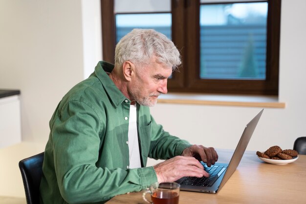 Medium shot man typing on laptop