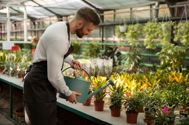 Medium shot man watering plants