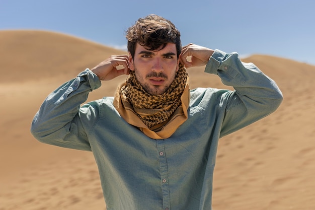 Free photo medium shot man wearing scarf in desert