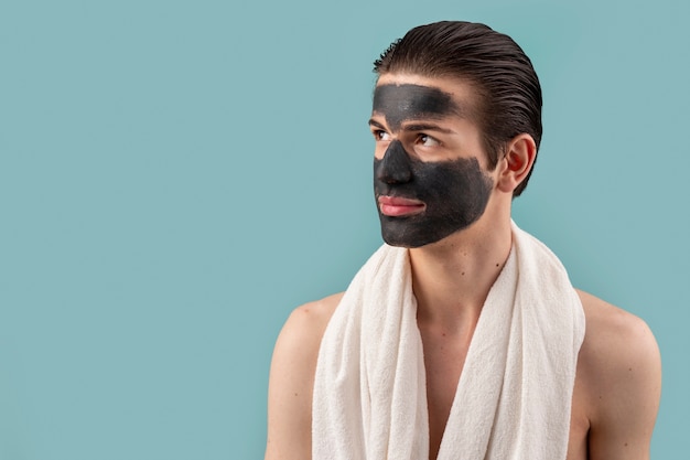 Free photo medium shot man with face mask and towel