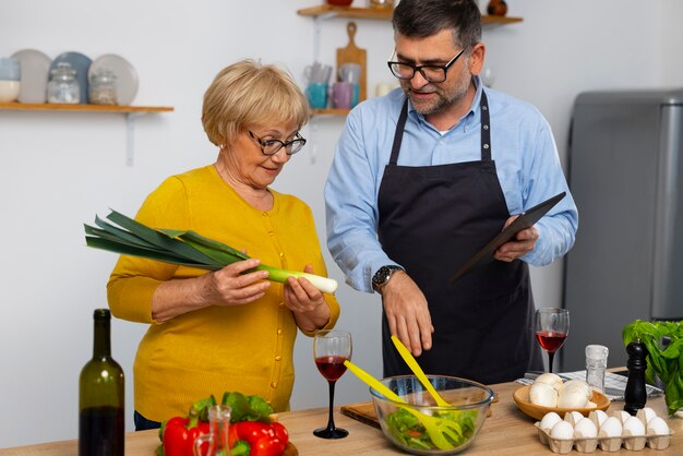 Medium shot man and woman cooking in kitchen