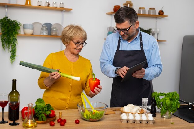 Medium shot man and woman cooking in kitchen