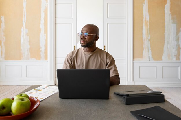 Medium shot man working on laptop