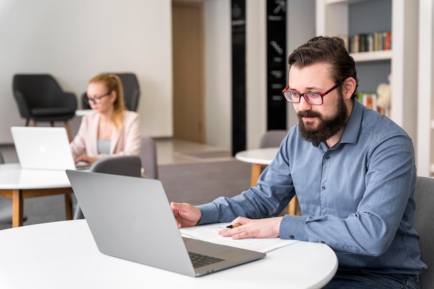 Medium shot man working with laptop