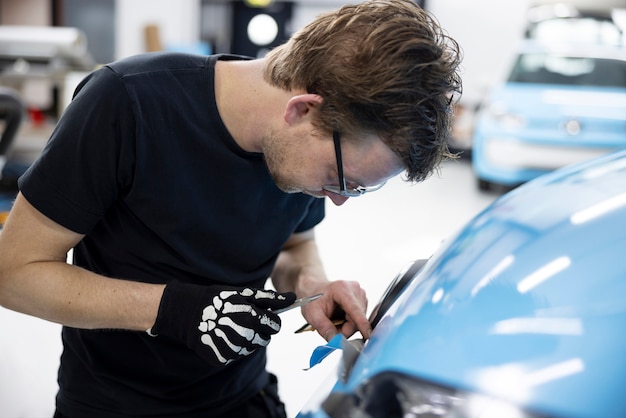 Free Photo medium shot man wrapping car at job