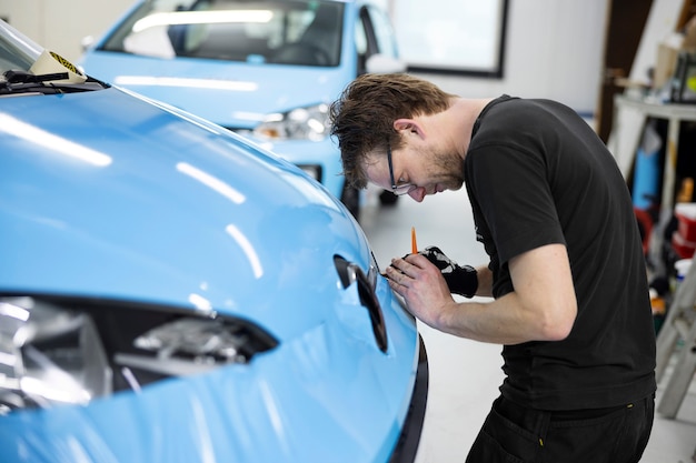 Free Photo medium shot man wrapping car at work