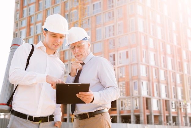 Free Photo medium shot men with building scaffolding