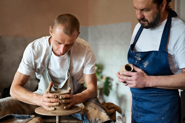 Free photo medium shot men working with clay