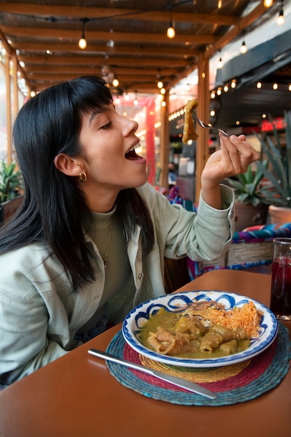 Medium shot mexican woman eating ranchero food