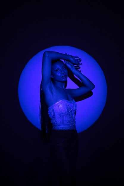 Free photo medium shot model posing in blue light