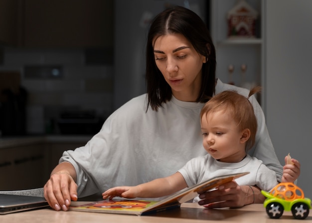 Medium shot mother and baby with book