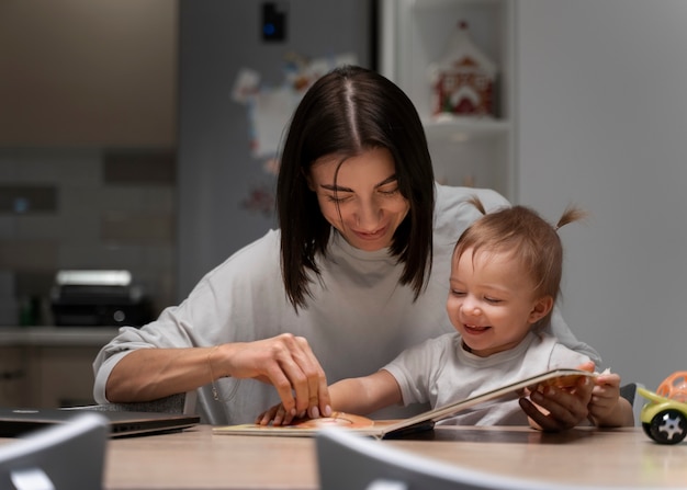 Medium shot mother and baby with book