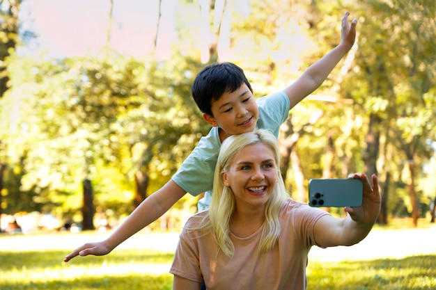 Free Photo medium shot mother and boy taking selfie