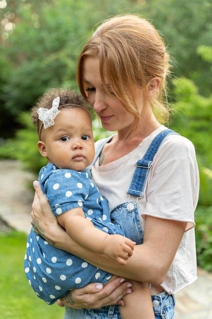 Medium shot mother holding baby