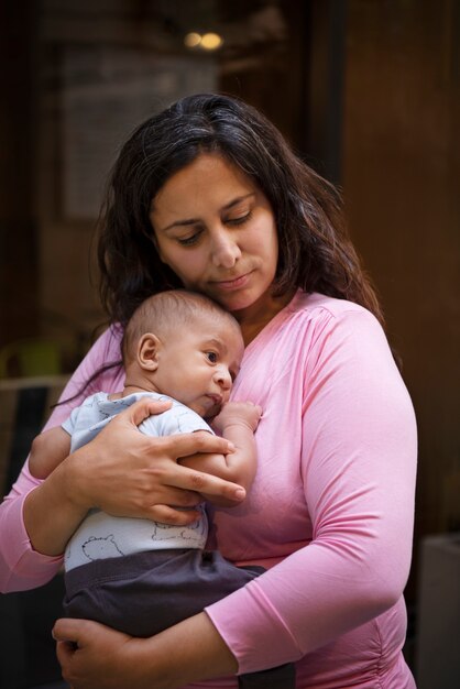 Medium shot mother holding baby