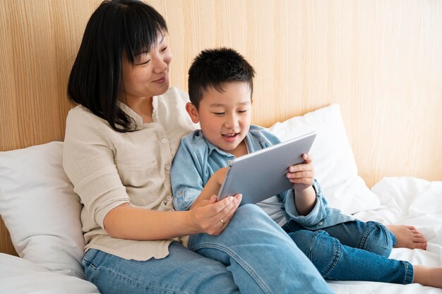 Medium shot mother and kid with tablet