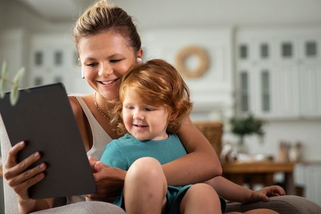 Medium shot mother and kid with tablet