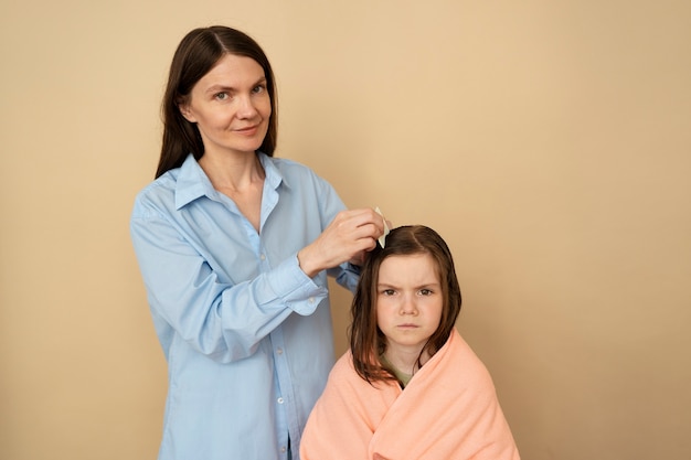 Free Photo medium shot mother using hair comb