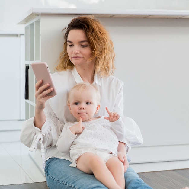 Free photo medium shot mother with kid on floor