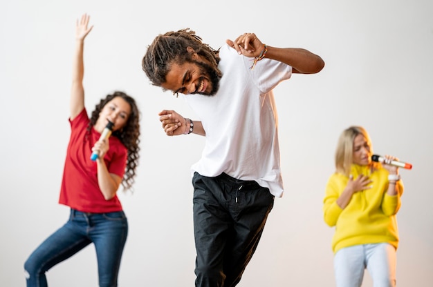 Free photo medium shot multiracial people singing and dancing