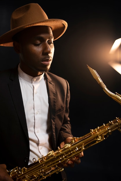 Medium shot musician in suit holding saxophone