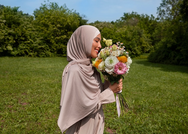 Medium shot muslim woman posing with flowers