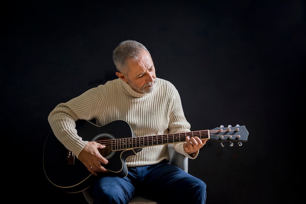 Medium shot old man playing guitar