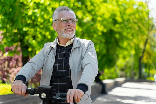 Free photo medium shot old man with scooter outside