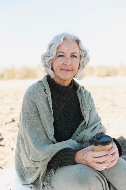 Free photo medium shot old woman on the beach