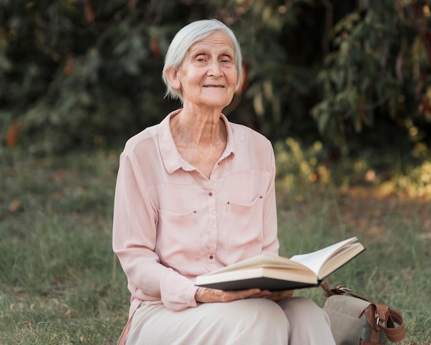 Free photo medium shot old woman holding book