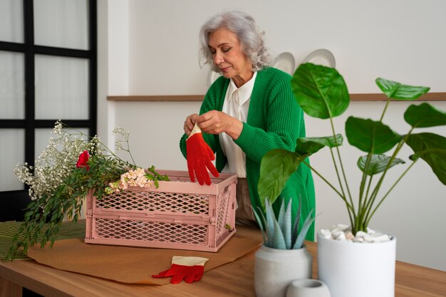 Medium shot old woman taking care of plants