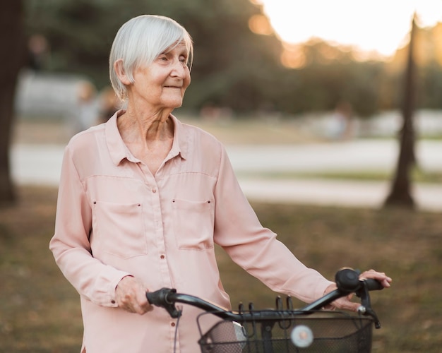 Medium shot old woman with bicycle