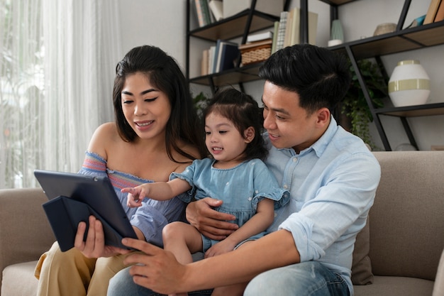 Medium shot parents and kid with tablet