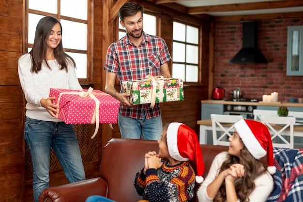 Free photo medium shot parents surprising children with gifts