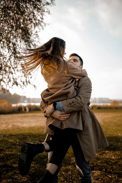 Free photo medium shot partners hugging outdoors