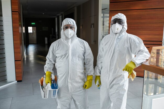 Medium shot people cleaning in hazmat suits