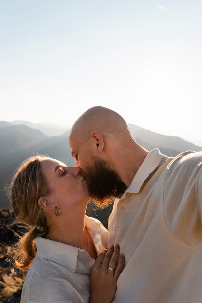 Medium shot people kissing in nature