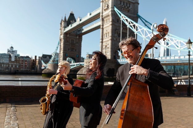 Free Photo medium shot people making music outdoors