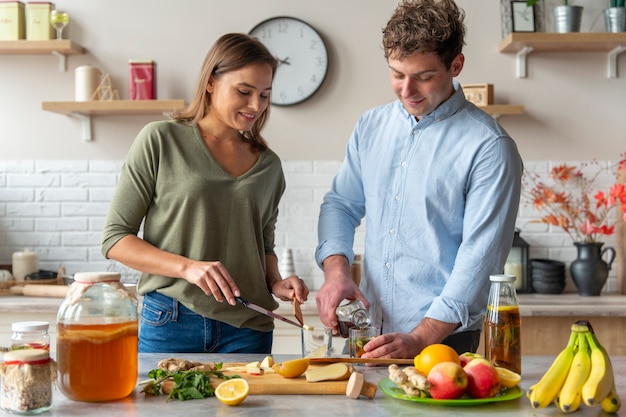 Medium shot people preparing kombucha at home