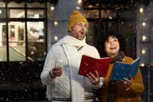 Free photo medium shot people singing christmas carols