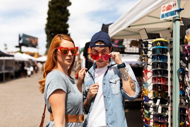 Free Photo medium shot people trying on sunglasses