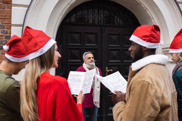 Free photo medium shot people wearing santa hats