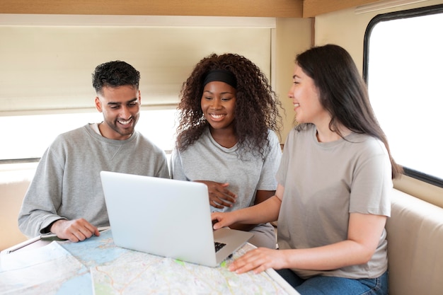 Medium shot people  with laptop in campervan