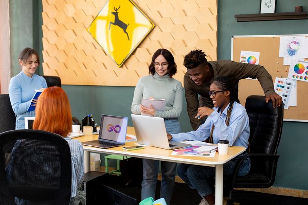 Medium shot people working together at desk