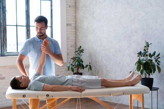 Medium shot physiotherapist helping patient