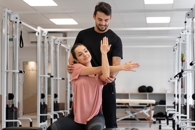 Medium shot physiotherapist helping woman