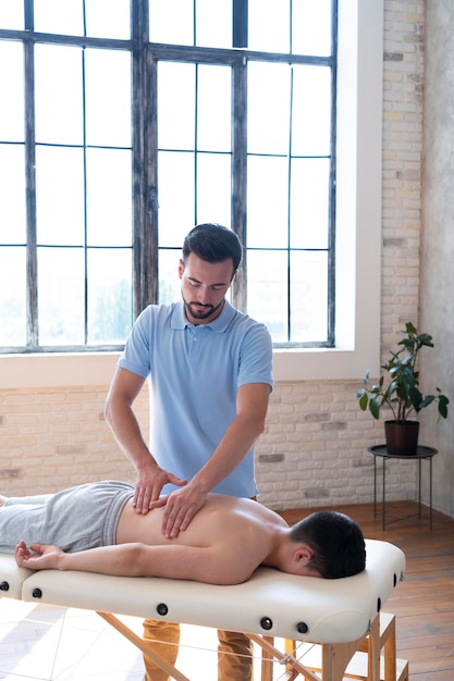 Medium shot physiotherapist massaging patient