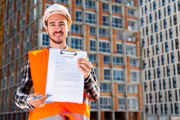 Free Photo medium shot portrait of construction engineer holding contract