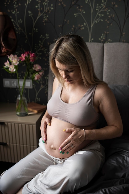 Medium shot pregnant woman indoors